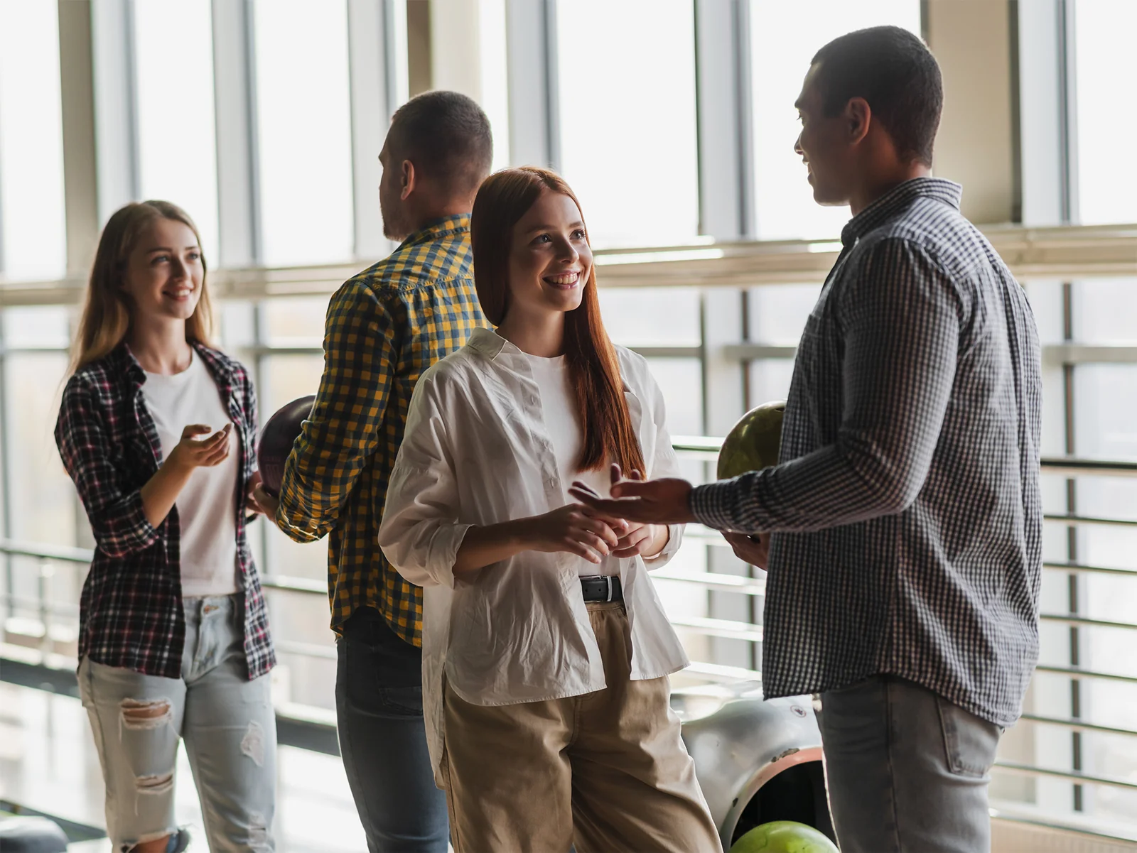 Attendees chatting and laughing together at a bowling alley social event