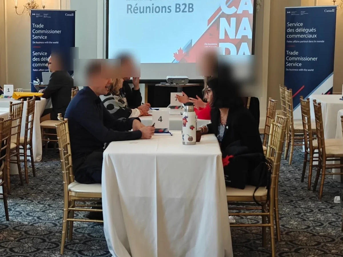 Attendees in one-on-one B2B meetings at numbered tables during a Trade Commissioner Service event