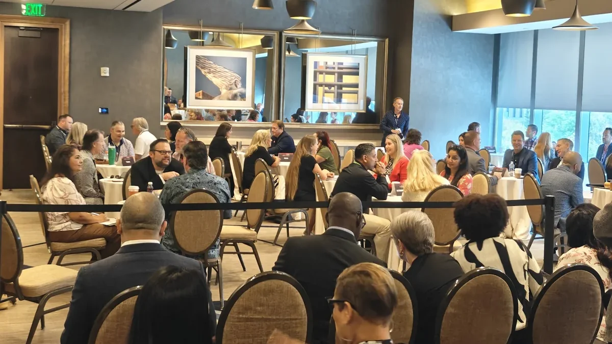 Conference attendees talking at round tables during a networking breakfast