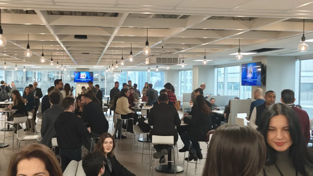 Attendees networking at tables during a Turks in Tech meetup in Toronto.
